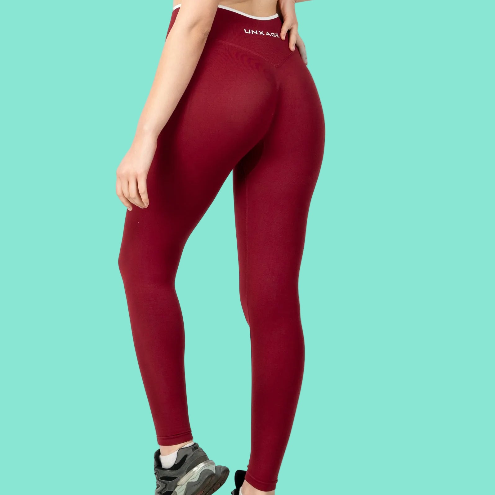 Person wearing red leggings with a visible brand logo on a white background