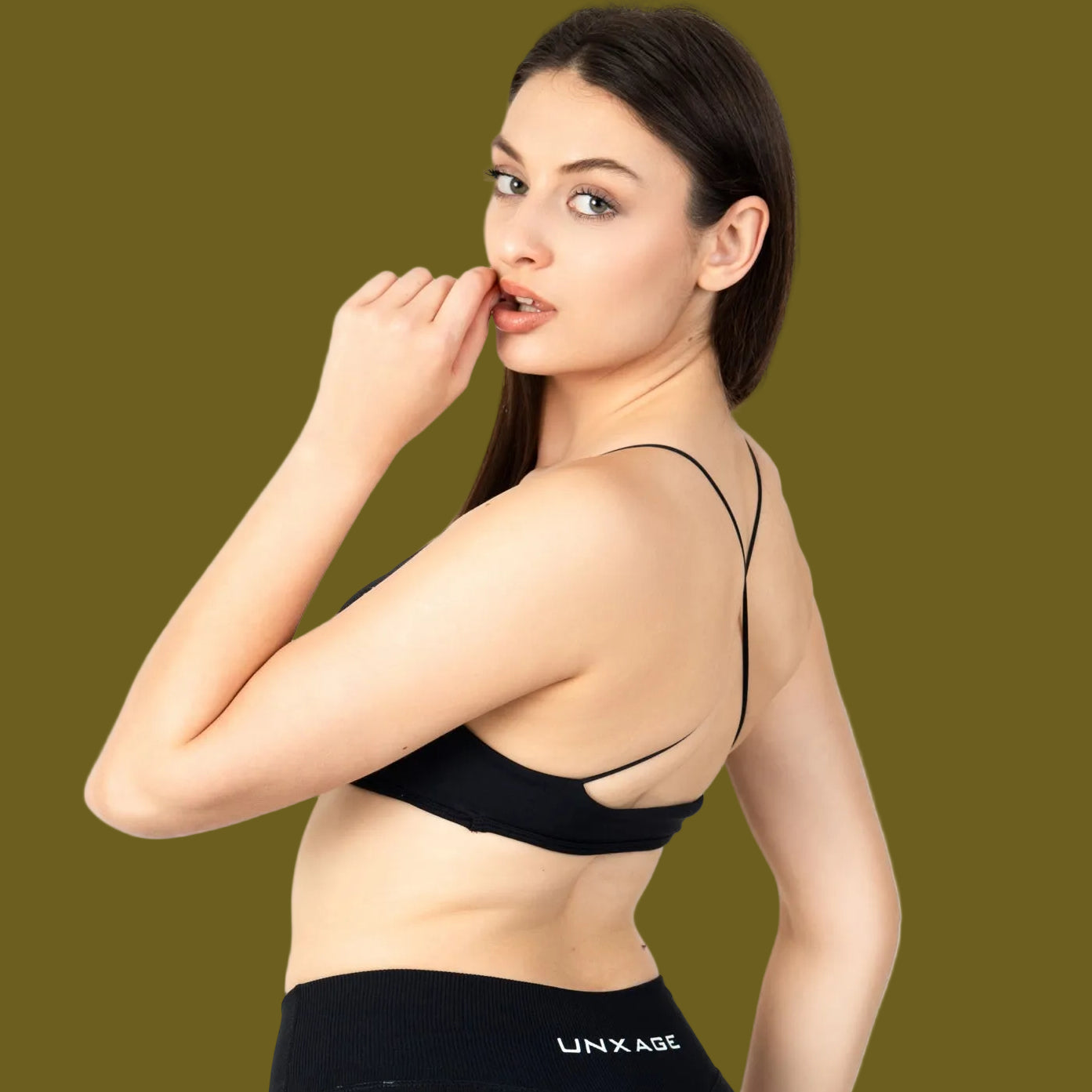 Woman wearing a black sports bra and leggings with 'Lynx' branding on a white background