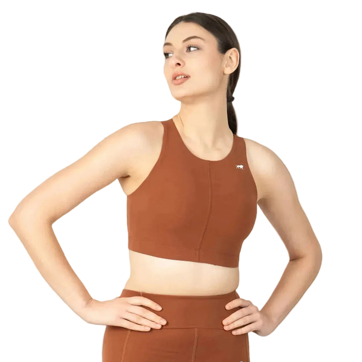 Woman wearing a brown sports bra and leggings on a brown background