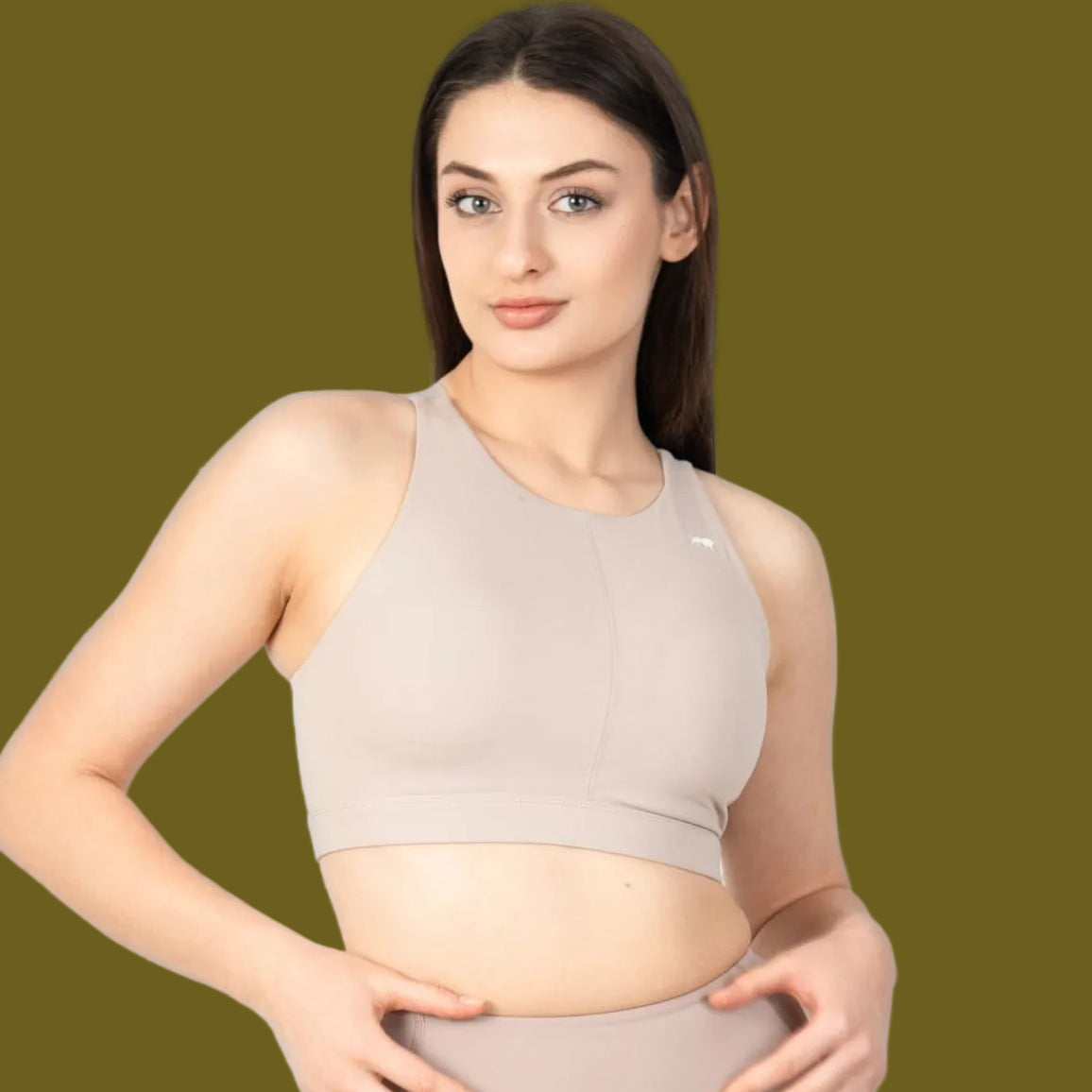 Woman wearing a beige athletic outfit on a light gray background