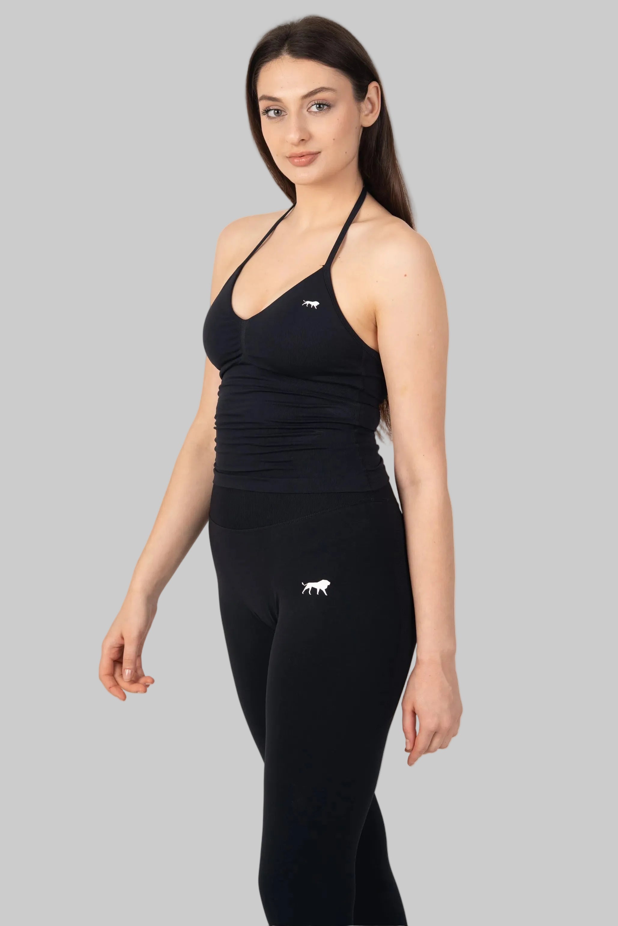 Woman wearing a black sports outfit with a logo on a white background