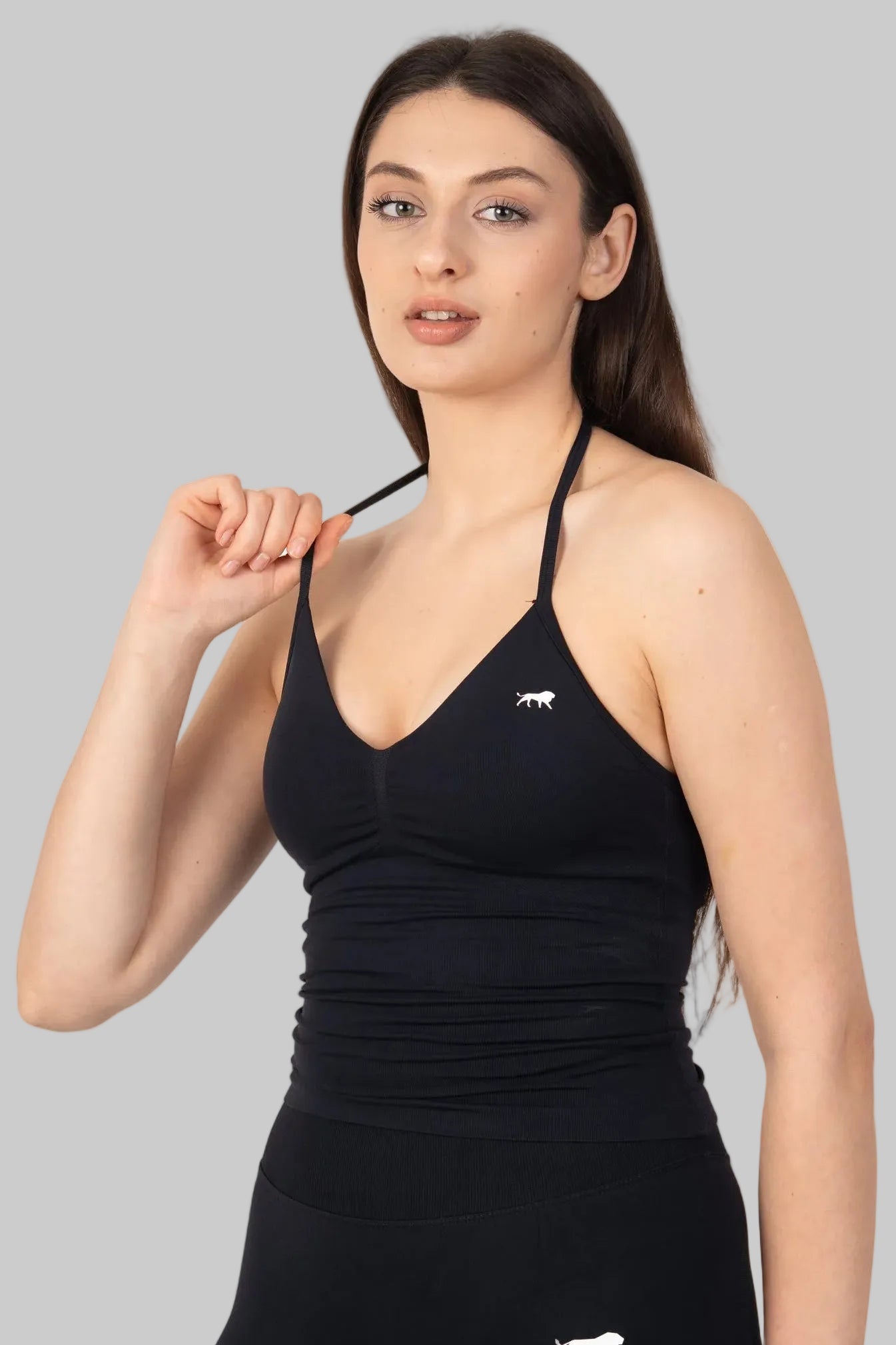 Woman wearing a black athletic outfit with a logo on a white background