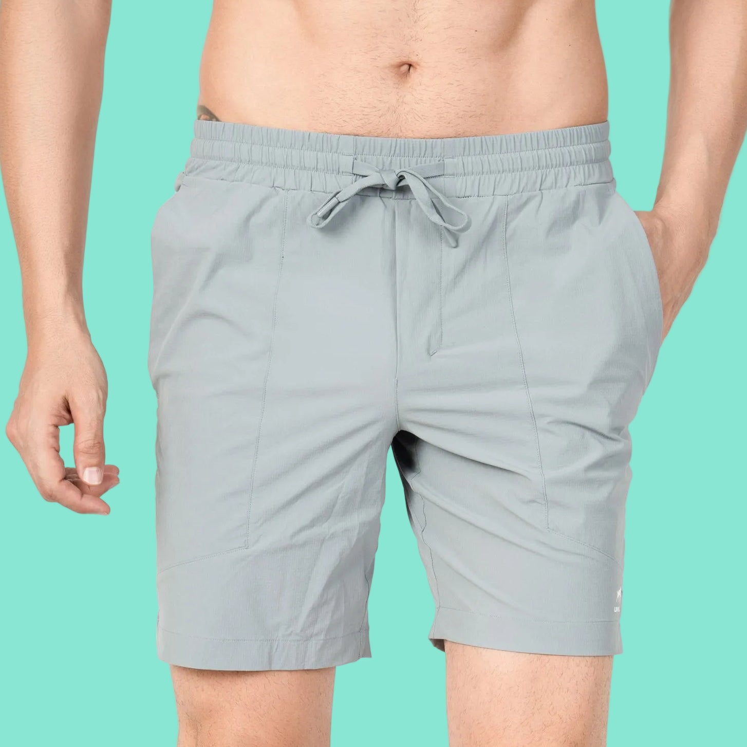 Person wearing light gray shorts on a plain background